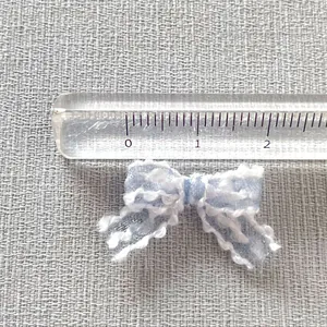 Light blue 2cm lace bow with white scalloped edges and scale ruler for size DIY reference