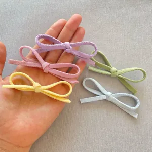 Dettaglio di piccoli fiocchi in tessuto fatti a mano in colori pastello per accessori fai da te