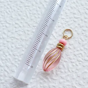 Makroaufnahme: 2,5cm rosa Tropfen-Acrylanhänger mit goldener Metallöse und Perle