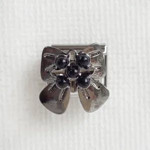 Détail du charm aile de chauve-souris en métal foncé avec perles noires pour bracelet