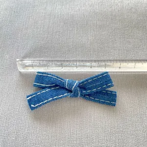 Blue denim bow with white stitching measured at 5.5cm for DIY clothing crafts