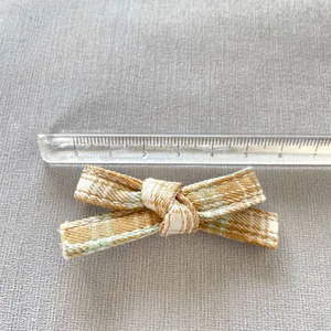 Detail of a 7.5cm yellow plaid bow accessory for DIY crafts and doll clothing decor