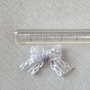 Macro d'un petit nœud en résille lilas de 3 cm avec règle pour l'échelle de taille