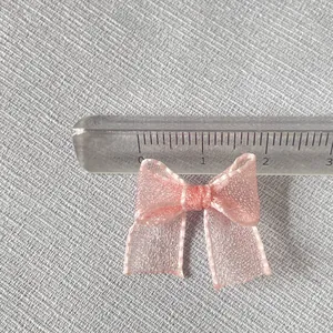 Macro shot of a 2.5cm pink organza mini bow with ribbon for DIY craft accessories