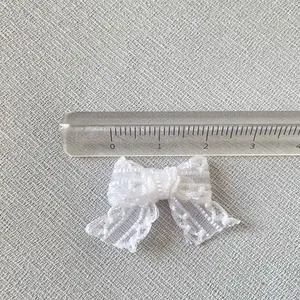 Vue macro d'un mini nœud en dentelle blanche de 3 cm pour accessoires et couture