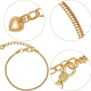 Detail view of golden snake chain bracelet featuring heart pendant and lobster clasp closure