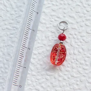 Detailaufnahme eines 22mm handgefertigten roten Acryl-Anhängers mit Linealmaßstab