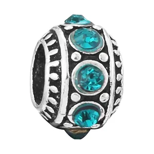 Silver bead charm with faceted green emerald stones and vintage floral engravings