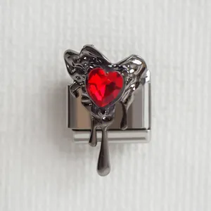 Détail du charm italien avec texture lave noire et cristal de cœur rouge facetté