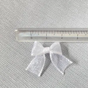 Detailed view of 30mm white organza ribbon bow measured with transparent ruler
