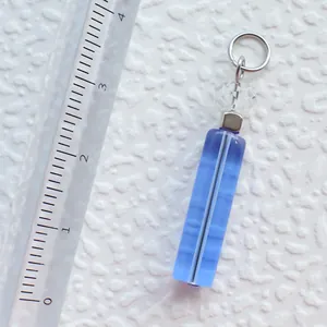 Detaillierte Makroansicht eines blauen Harzanhängers mit Lineal zur Größenmessung