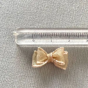 Macro shot of a 2.5cm champagne organza ribbon bow for DIY nail art and craft accessories