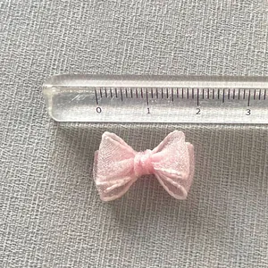 Close-up of a 1.5cm pink organza mini ribbon bow for DIY nail art and handmade crafts