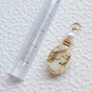 Makro-Detail eines 3cm Vintage-Cameo-Anhängers mit Perle und Gold-Finish-Anhängern