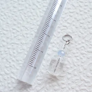 Makro-Detail eines geometrischen Acryl-Anhängers mit Lineal zur Größenmessung