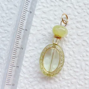 Detailansicht eines gelben Acryl-Anhängers mit Goldgravur und 3,8 cm Größenmessung