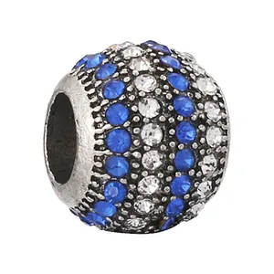 Macro shot of silver bead charm with blue and clear pavé crystals for DIY bracelets