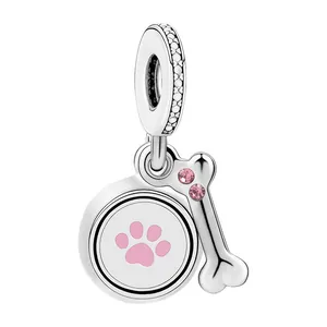 Dettaglio di ciondoli in lega d'argento con impronta di zampa e osso con strass rosa