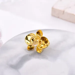 Exquisite golden orchid bead with matte finish and center gemstone on marble tray