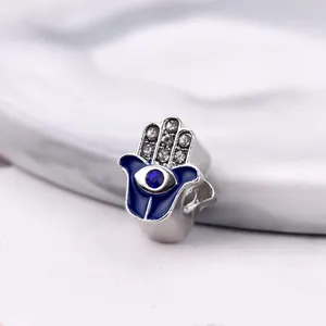 Gros plan d'une breloque Hamsa en argent avec émail bleu et détails en zircon brillant