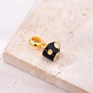 Detailed macro view of an elegant black and gold coffee cup charm for DIY bracelets.