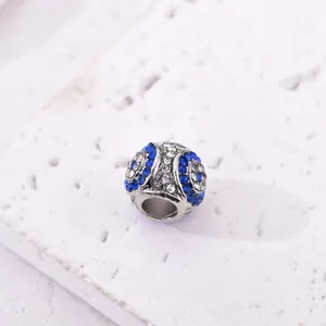 Vista macro di ciondolo a sfera d'argento con zirconi blu e trasparenti per braccialetti