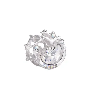 Detailed macro view of silver crescent moon charm with iridescent gemstone and small crystals