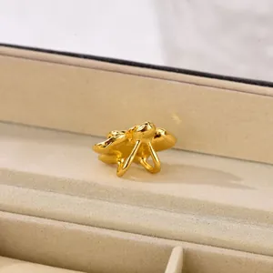 Macro side view of golden orchid flower petal charm on beige velvet jewelry box lining