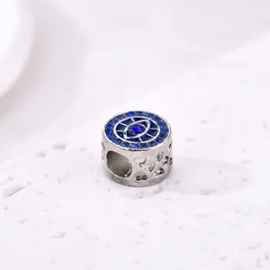 Macro-opname van de Evil Eye-bedel met blauwe kristallen en hartvormige opengewerkte zijden