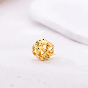 Makroaufnahme einer goldenen hohlen Herzperle mit poliertem Metallic-Finish für DIY-Schmuck