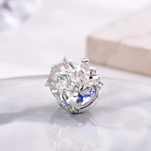 Macro shot of silver crescent moon charm with sparkling crystals on marble surface