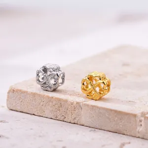 Makroaufnahme von ineinandergreifenden hohlen Herzanhängern in Silber und Gold