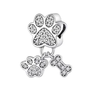 Macro shot of silver-tone paw and bone charm with pavé cubic zirconia accents
