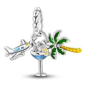 Detail of travel charms featuring a plane, cocktail glass, and palm tree pendant