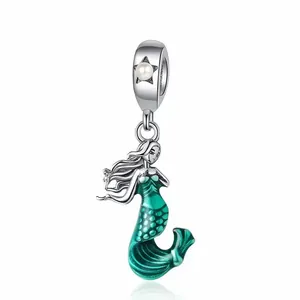 Detailed view of silver mermaid charm with green enamel scales and a single white pearl