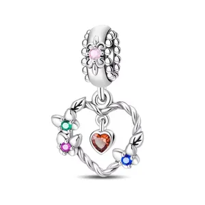 Intricate hollow heart charm with colorful zircon stones and red gemstone dangle