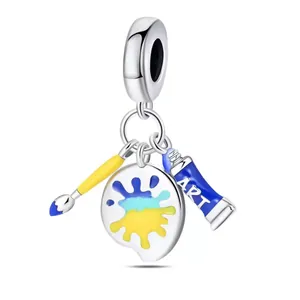 Art theme DIY charm set featuring a paint palette, brush and tube in colorful enamel