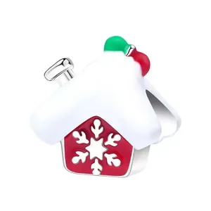 Macro shot of red Christmas house charm with white snowflakes and snowy roof detail