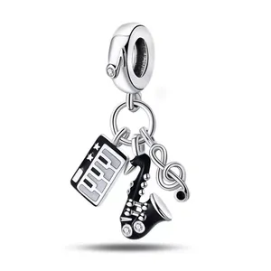 Silver music charms with piano keyboard saxophone and treble clef on white background