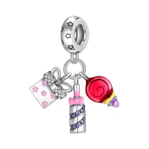 Detailed view of silver charms featuring a pink gift box and a red spiral lollipop