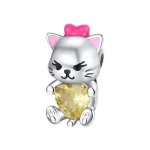 Macro view of cartoon cat charm with pink bow and large yellow heart faceted gemstone