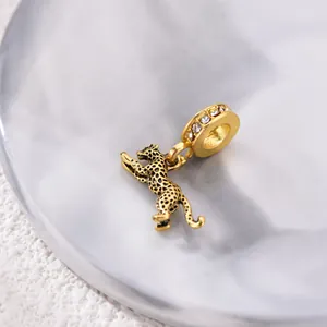 Detalle macro de un dije de leopardo dorado con diamantes de imitación para joyería
