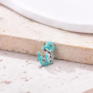 Detailed blue enamel chameleon charm in silver finish on natural stone background