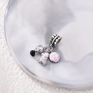 Silver bead charm featuring skull, bride figurine, and pink heart plaque on marble base