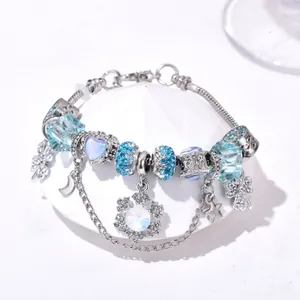 Vue macro de perles en cristal bleu et breloques flocon sur un bracelet argenté