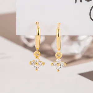 Elegant gold four-leaf flower huggie earrings with sparkling clear cubic zirconia stones