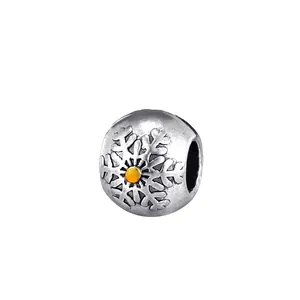 Detailed macro shot of a vintage silver snowflake bead with an orange center gem