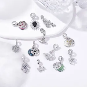 Macro shot of silver insect pendants with colorful zirconia stones and enamel details
