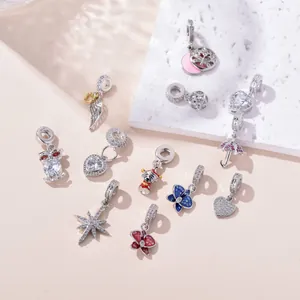 Macro detail of cubic zirconia star and floral charms with silver finish and colorful enamel