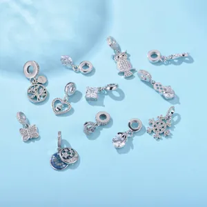 Silver cubic zirconia charms set featuring heart, snowflake and tree of life on blue background